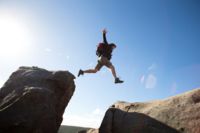 Angajatul CANCOM Austria practică sporturi extreme de alpinism, sărind de pe o stâncă în aer liber.