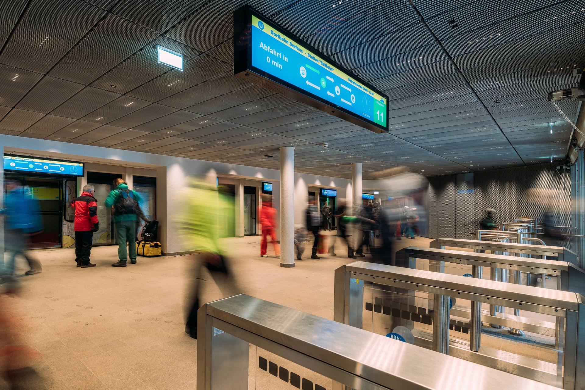Grup de persoane într-un aeroport, înconjurate de ecrane de semnalizare digitală de la CANCOM.
