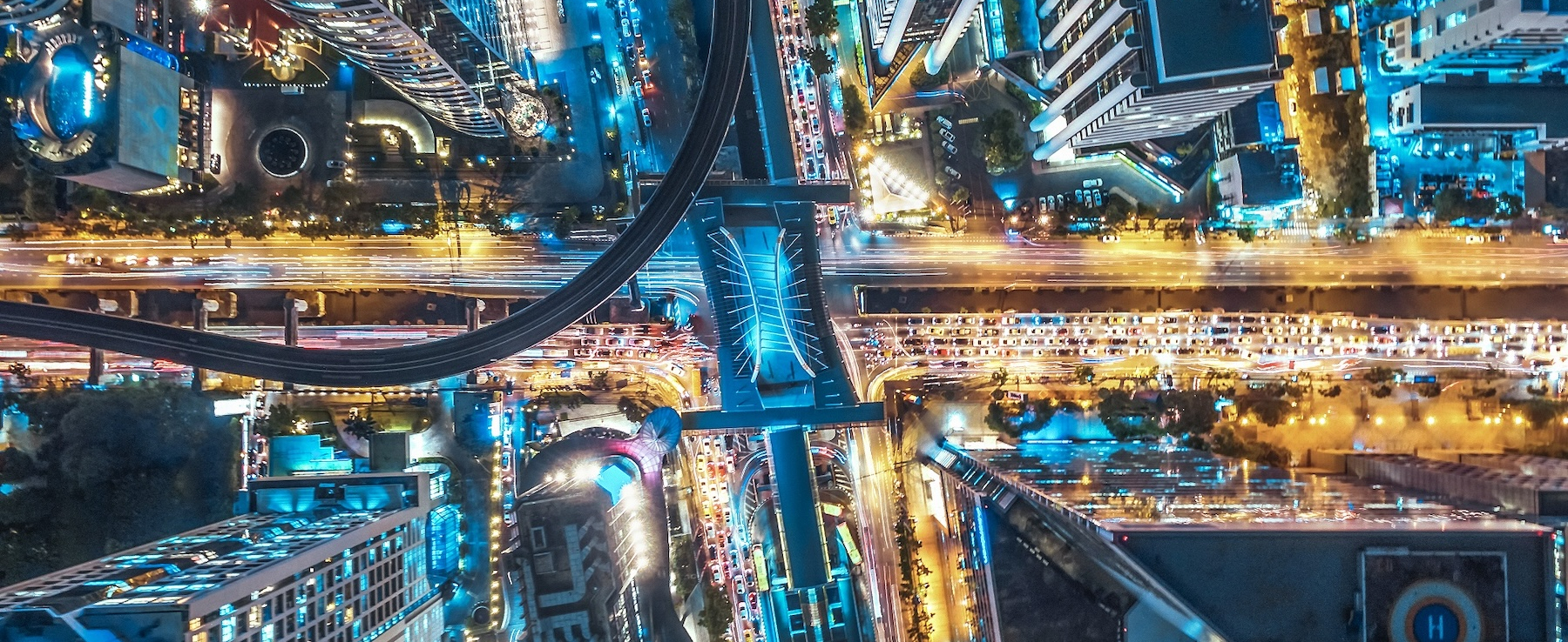 Vedere aeriană a unui oraș pe timp de noapte, luminat de numeroase lumini care simbolizează eficiența energetică urbană în contextul gestionării inteligente a energiei de către CANCOM.