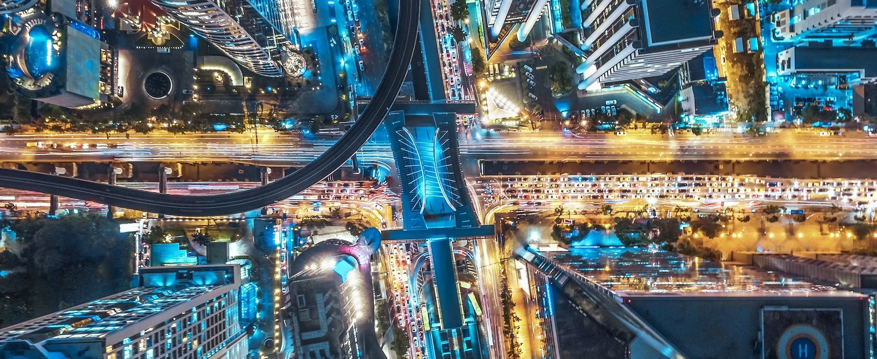 Vedere aeriană a unui oraș pe timp de noapte, luminat de numeroase lumini care simbolizează eficiența energetică urbană în contextul gestionării inteligente a energiei de către CANCOM.