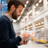 Un bărbat folosește o tabletă pentru planificare într-un birou.